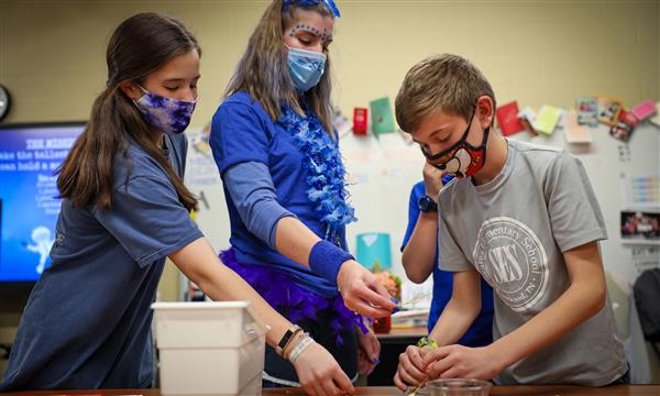 Teacher works with students to create tower